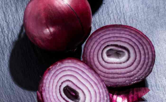 गर्मियों में प्याज का सेवन करते लोग, जो शरीर को ठंडक देने और लू से बचाव में मदद करता है