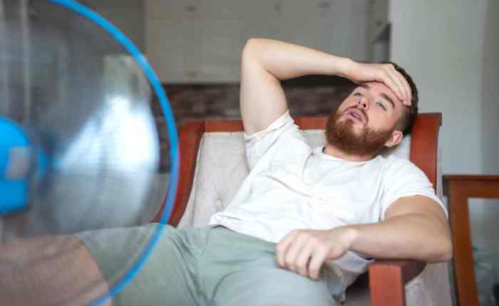 तेज गर्मी में लू (हीट स्ट्रोक) के कारण चक्कर महसूस करता व्यक्ति, सिर पकड़कर परेशान दिख रहा है.